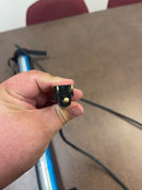 Detail of the Jameson shop light's ends, showing the power plug up close.