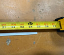 Close-up of a new white zip tie with a measuring tape, showing its actual length.