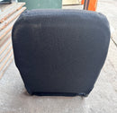 Back view of a new black cloth bucket seat lying flat, showing its rear contour and metal base.