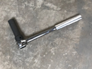 Side view of the heavy-duty ratchet wrench and its attached 14mm impact socket.